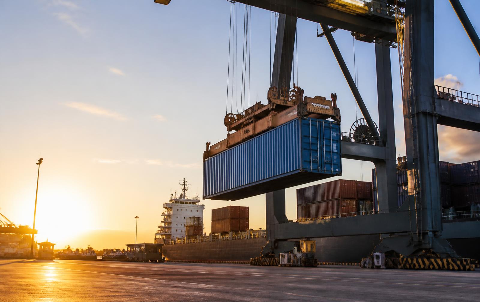 A shipping container being loaded at a port terminal